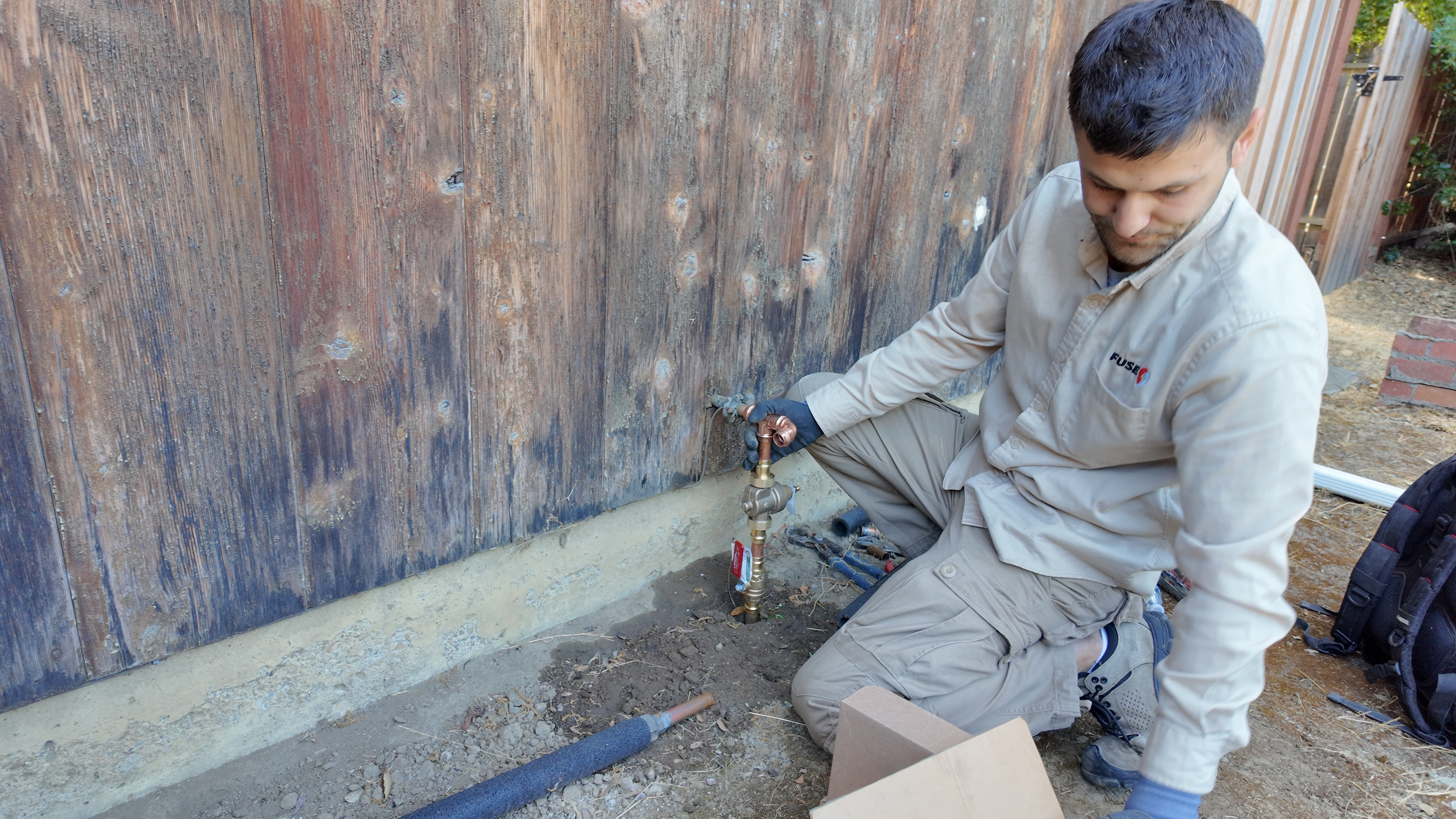 Plumber inspecting kitchen faucet water pressure