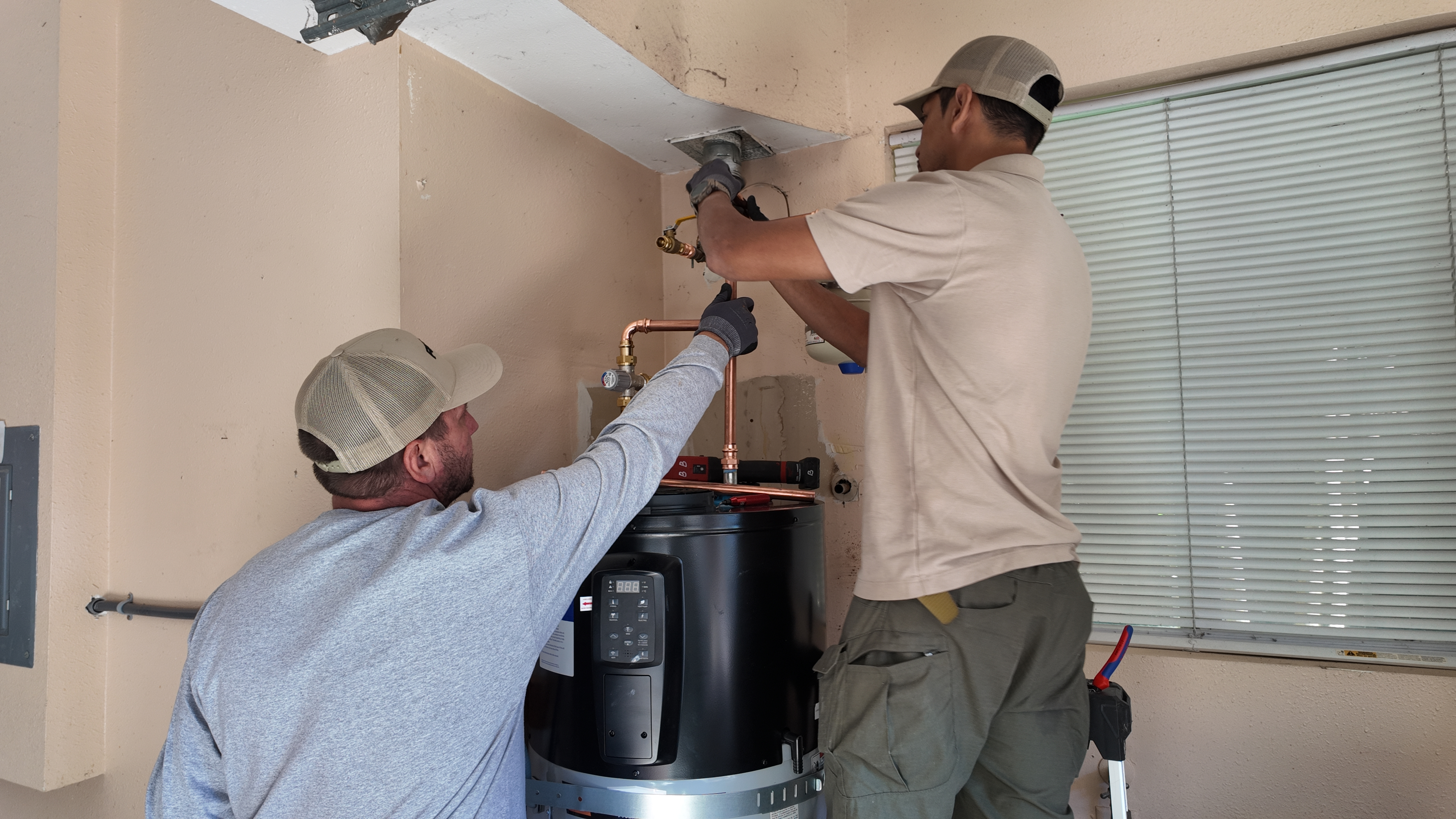 Technician testing hot water after tankless installation 